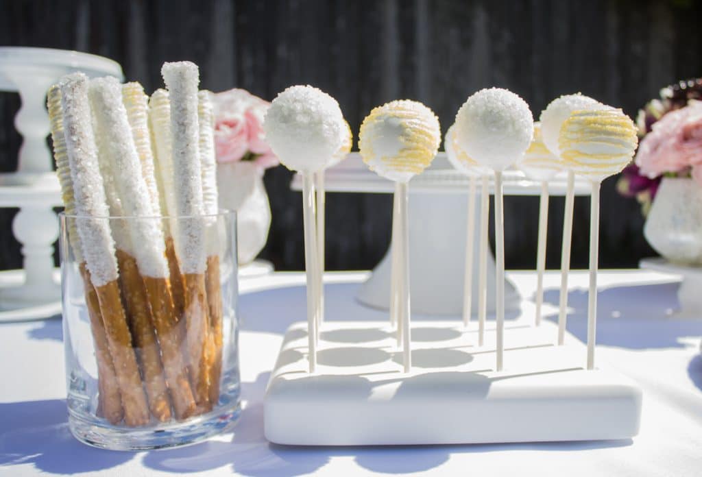 close up photo of dessert table, focused on cake pops and white chocolate dipped pretzels Orlando, FL