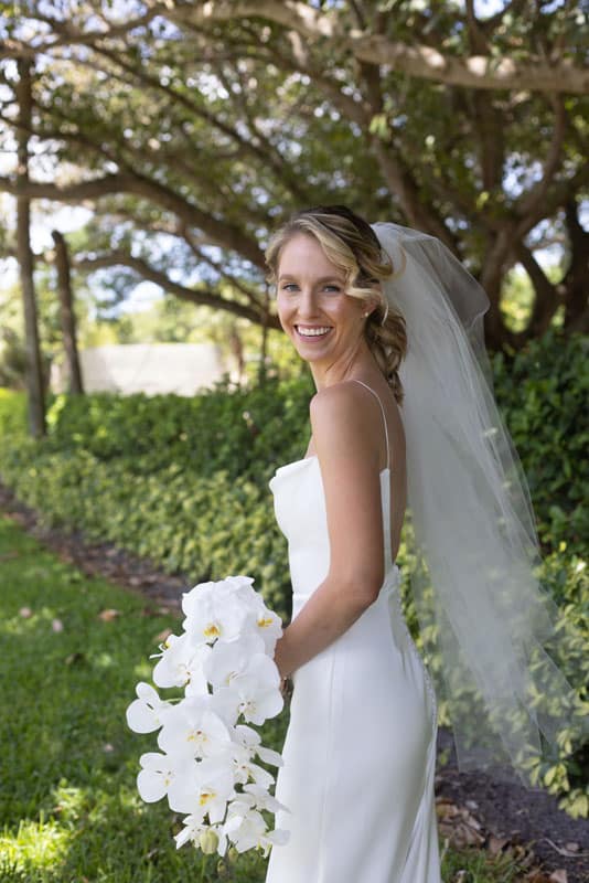 Bride in her gown, holding her white flower bouquet at a vineyard, posing for the camera, JVK Photography, Central FL