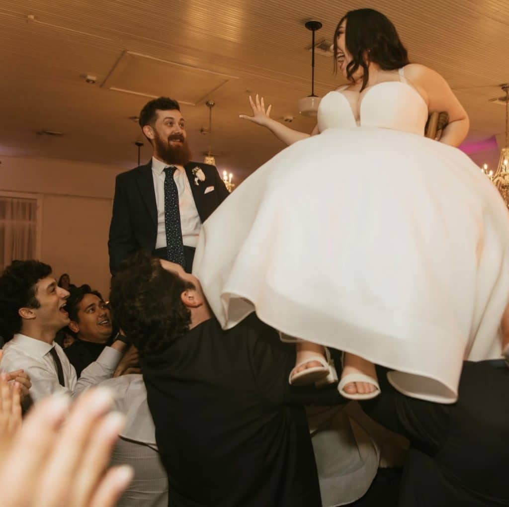 The bride and groom are lifted by guests during their reception, Kwik Entertainment