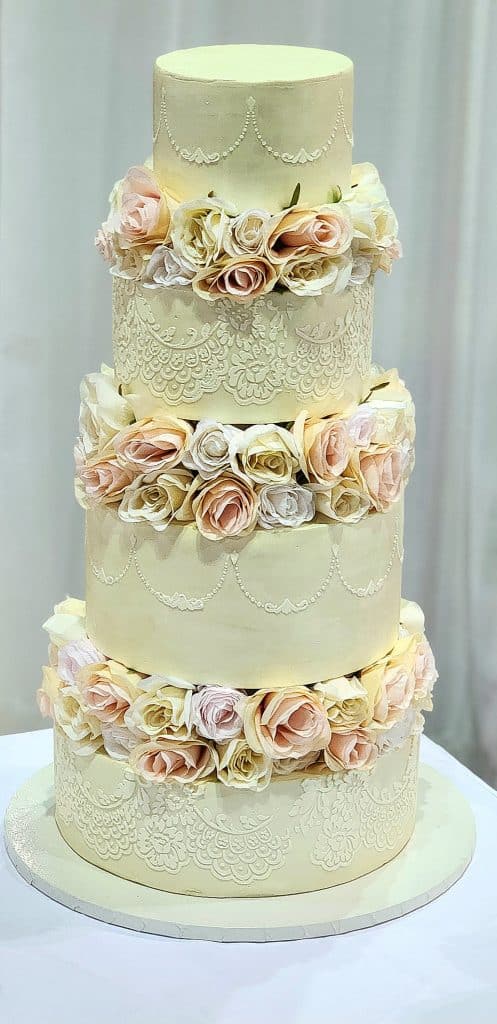 four tiered cake with white fondant, a layer of soft colored flowers in between each layer, Special Treats by Tanya, Orlando, FL