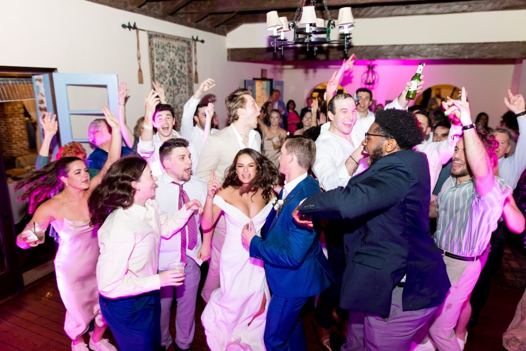 Dance party at a reception with pink uplighting, DJ Rey, Central FL