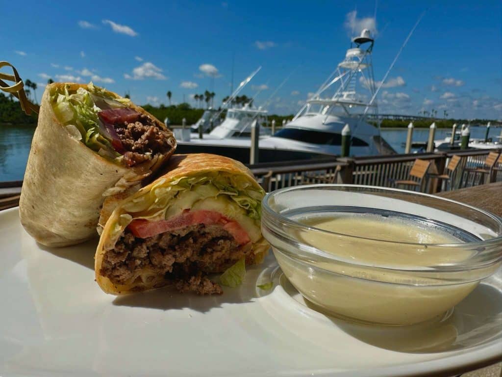 Enjoy a wrap with a bright dipping sauce by the water at Outriggers Tiki Bar & Grille, Central Fl