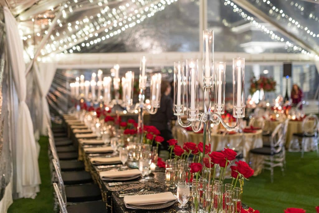 Indoor venue at World Equestrian Center, Red roses on the tabletops, champagne colored napkins, beautiful lighting, under the night sky, Orlando, FL