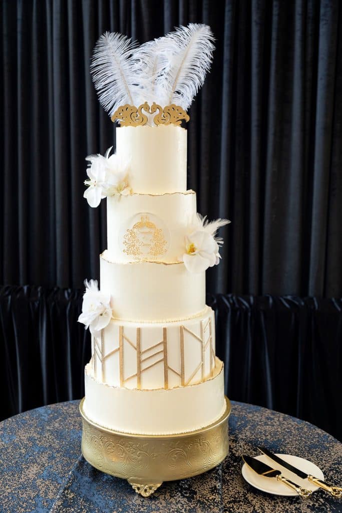 five tier wedding cake, all white with feathers on top and the sides, gold embellishments, orlando, fl