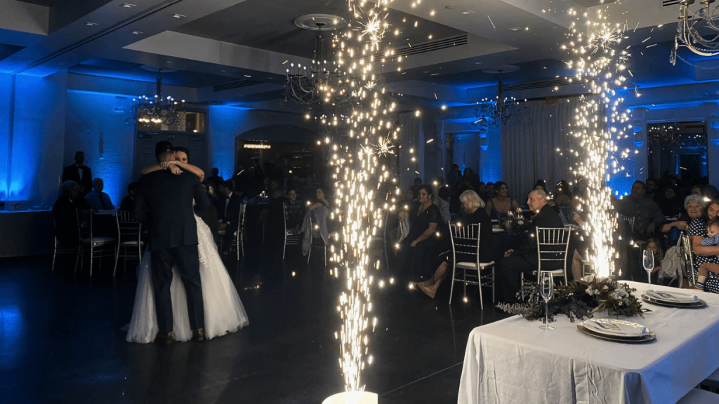 Ballroom set during a reception, bride and groom on the dance floor, while sparklers are set off near the head table, Central FL