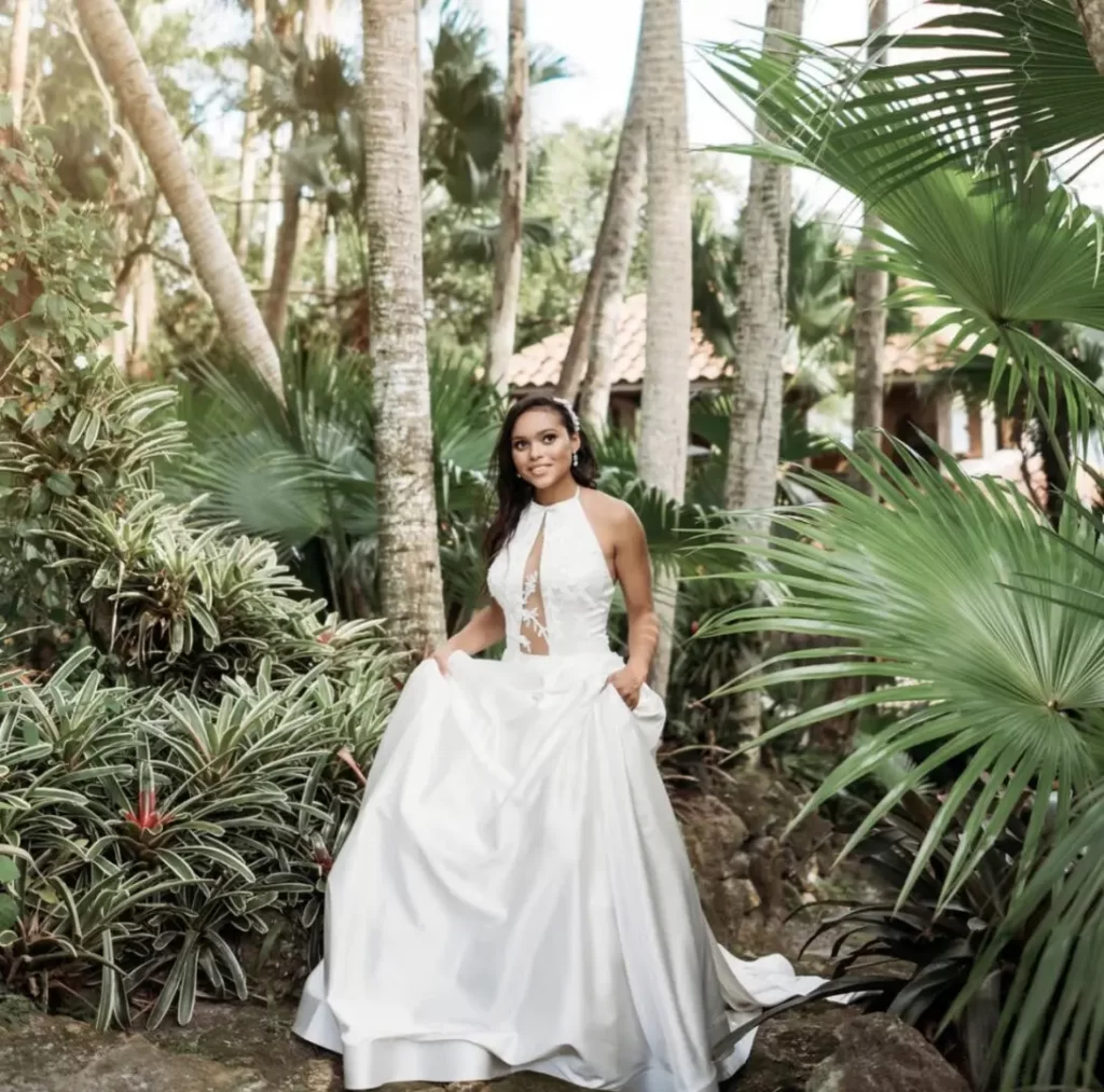 Bride walking in her wedding dress through the trees with palm frond all around, Orlando, FL