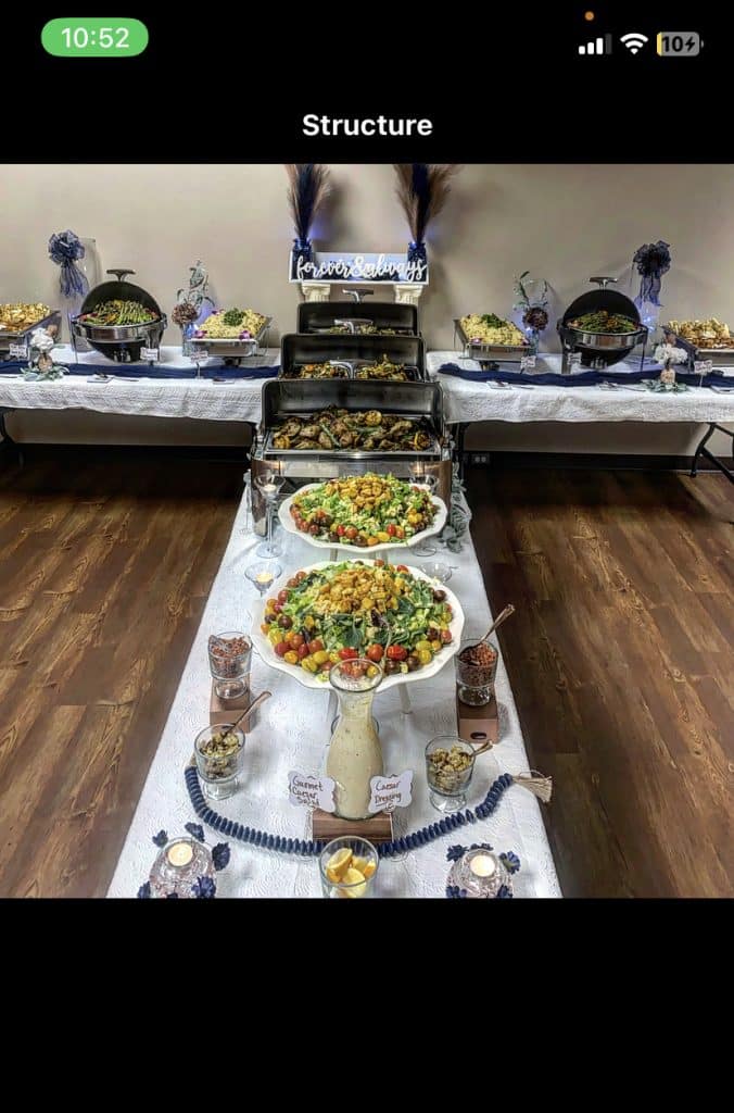 T-shaped tables with a double sided buffet display, white tablecloths, chaffing dishes, white bowls and platters with condiments surrounding, Queen Chef Catering, Central FL