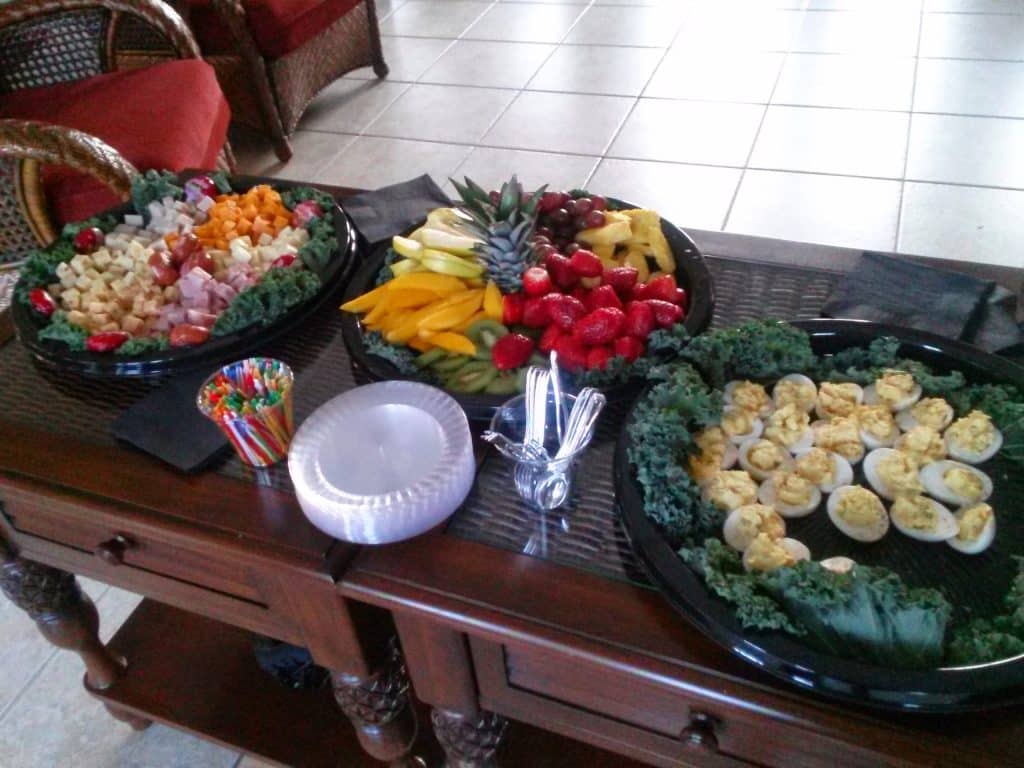 Small catering set up of deviled eggs on a black platter decorated with lettuce leaves, followed by a vegetable and fruit tray and a cheese tray, Teri & Co Catering Services, Central FL
