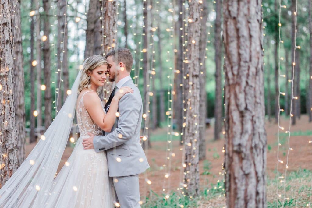 Bride and Groom in the woods among the trees with string lights hanging from the trees down to the ground, XOXO Sarai Photography, Central FL