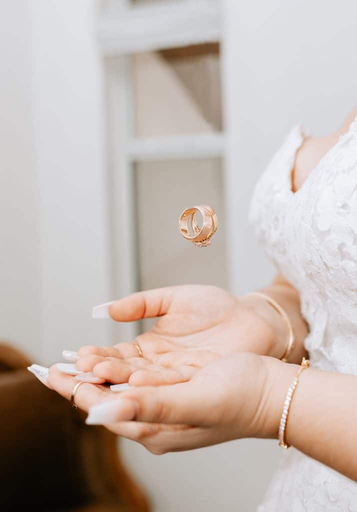 A bride tosses her rings in the air and holds out her hands together to catch them, XOXO Sarai Photography, Central FL