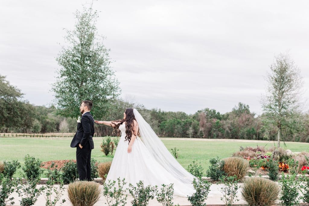 Beautiful ceremony set up with a bride looking towards her groom as he looks across the lawn, XOXO Sarai Photography, Central FL