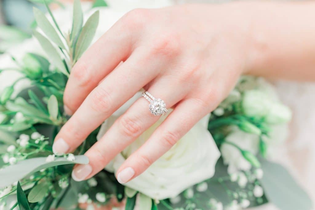 Close up photo of a bride's hand showing off her rings while holding her bouquet, Central FL