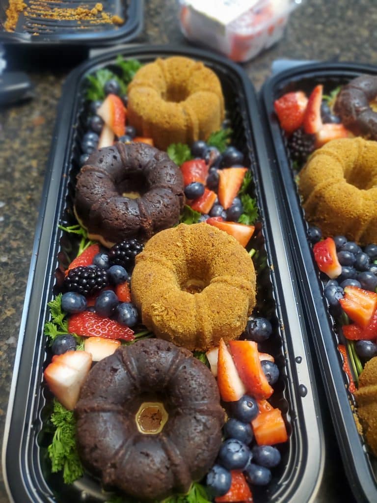 Dessert display of mini bundt cakes on top of a fresh fruit salad in long black boats, Teri & Co Catering Services, Central FL