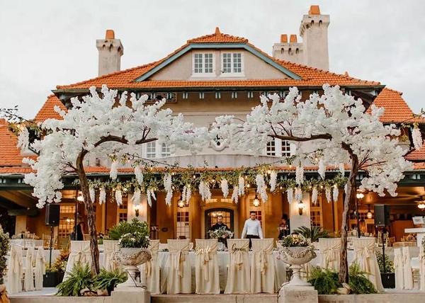 Sydonie Mansion, set up for a wedding reception with champagne tablecloths and white flowers on the trees, Orlando, FL