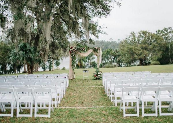 Outdoor wedding ceremony set up with white chairs set up with a center aisle with the altar at the front, Sydonie Mansion, Orlando, FL