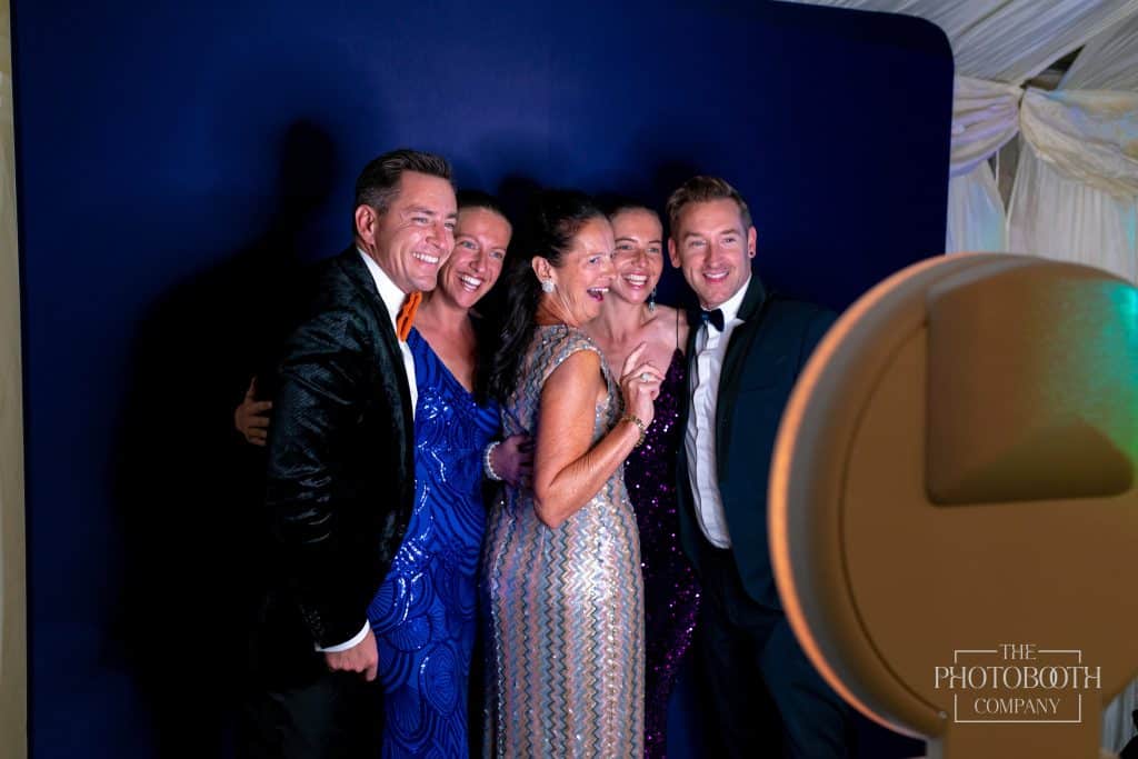 A group of friends meet at the photo booth, blue back drop, Central FL