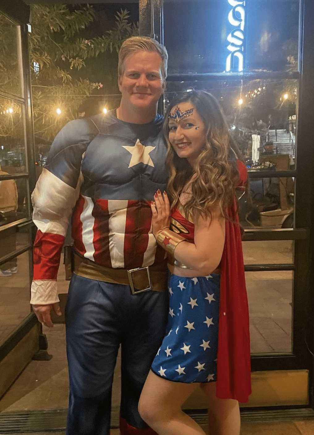 couple dressed up in superwoman and captain america costumes