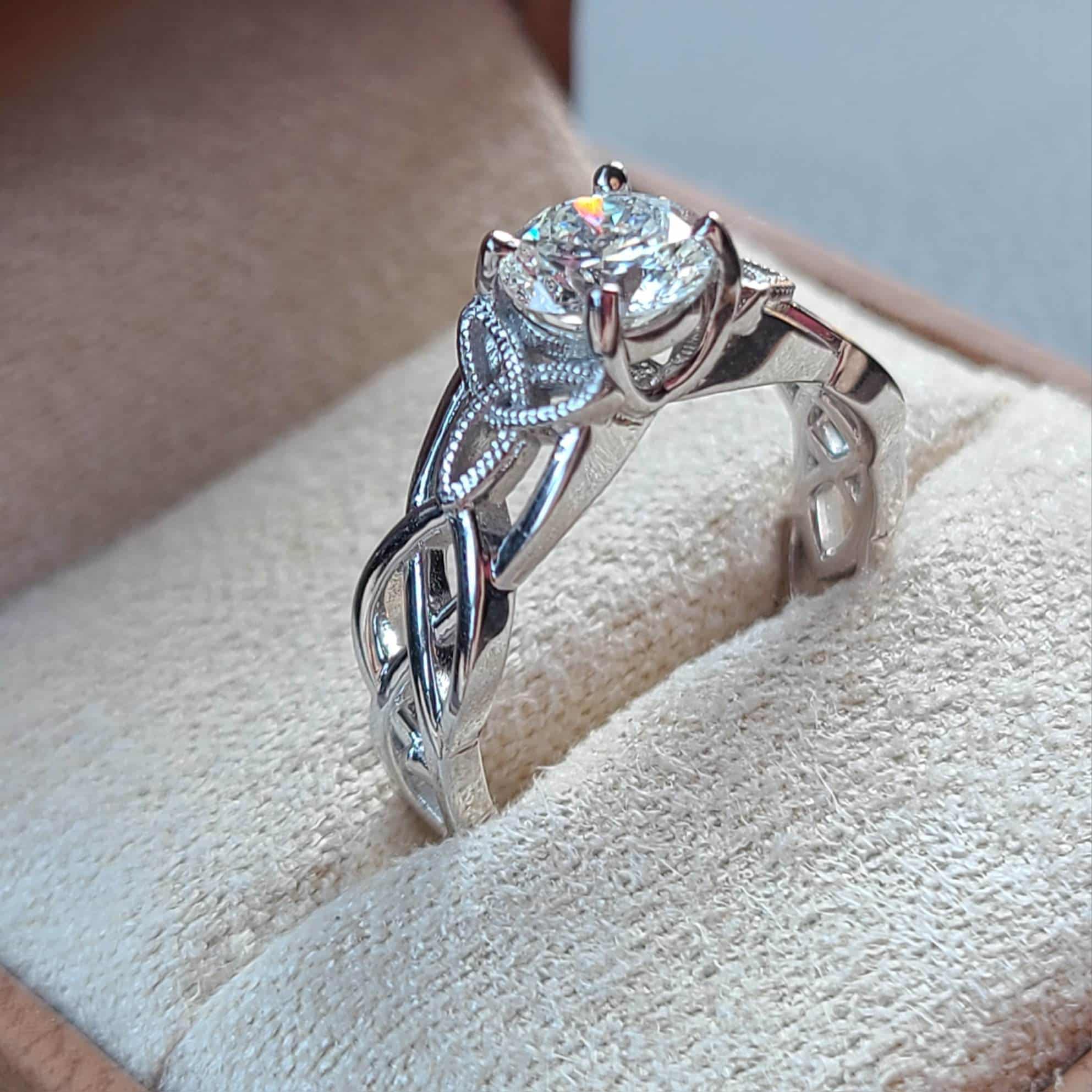 engagement ring with single stone in the center and intricate design on the band