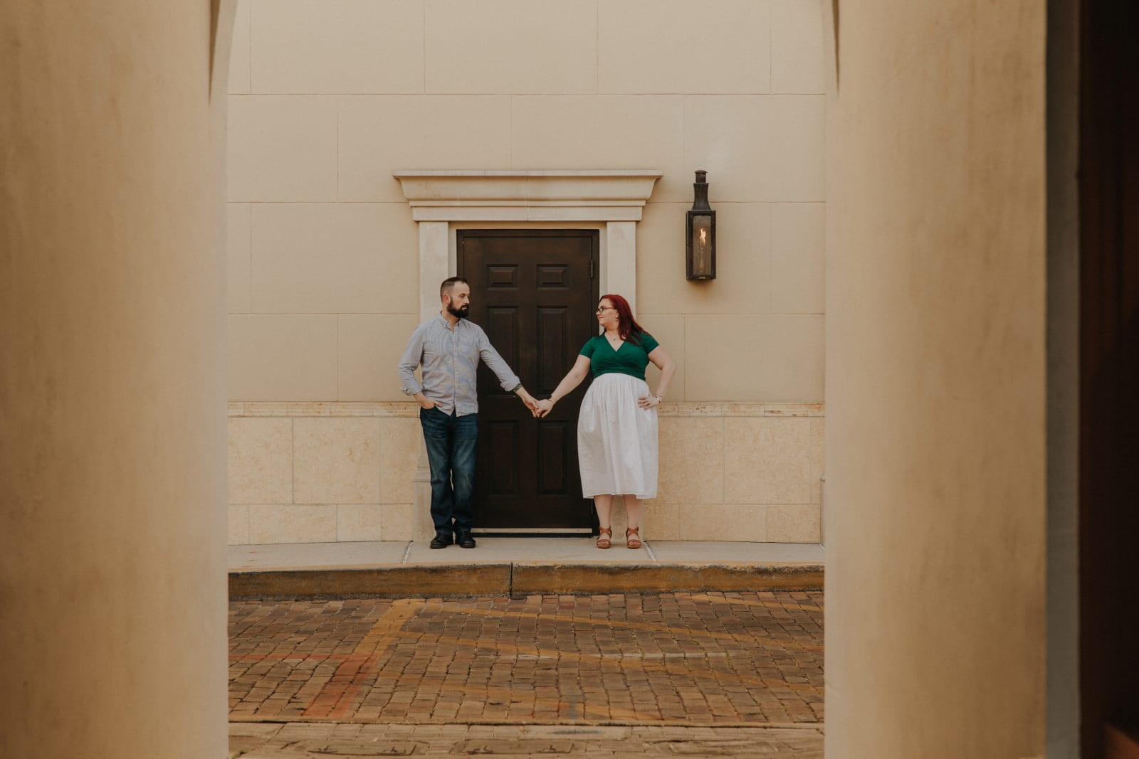 couple stand together in front of door holding hands