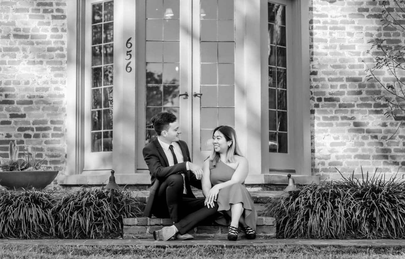 black and white picture of couple sitting on step in front of window