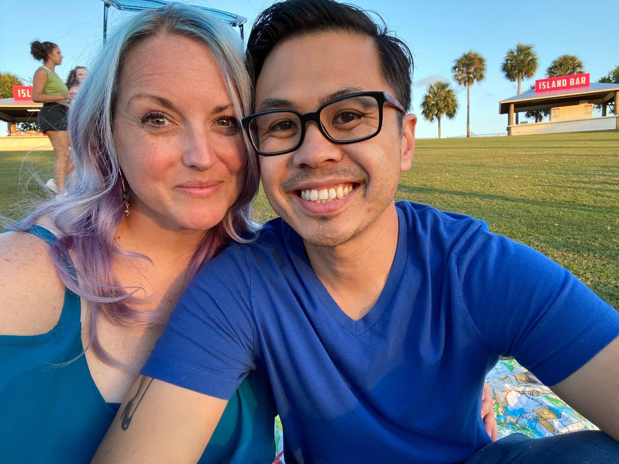 couple sit in the grass smiling together for selfie