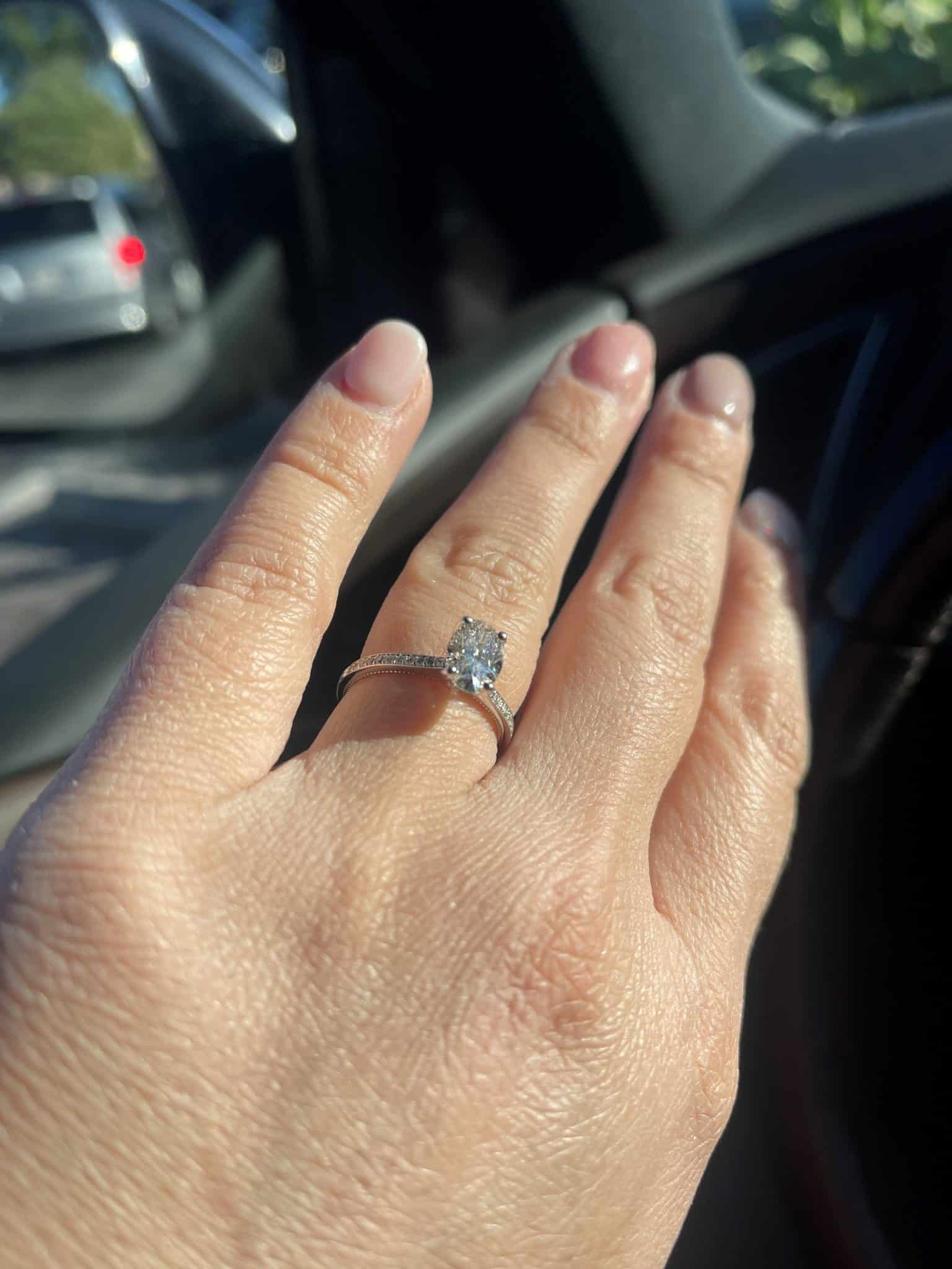 close up image of an engagement ring on a womans hand while in the car