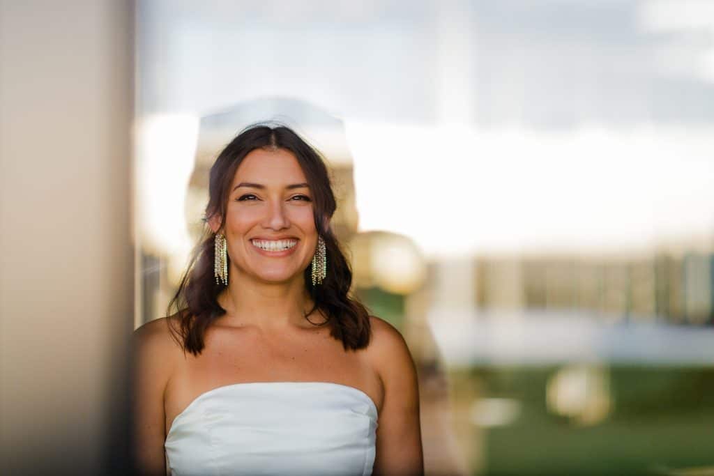 close up shot of the bride in front of class windows, smiling for the camera, Lavender on the Lake, Orlando, FL