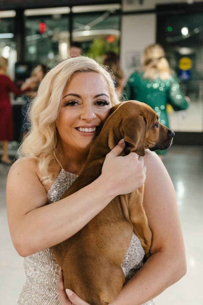 Bride holding her dog in her arms, outside a store front, Orlando, FL