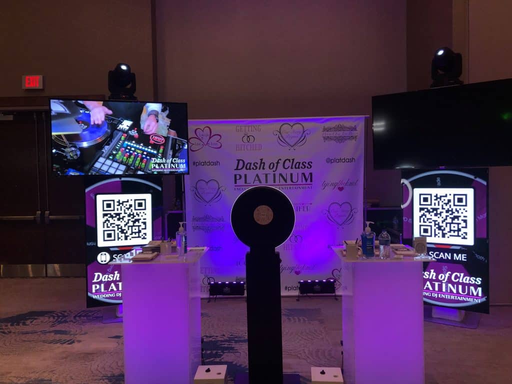 photo booth set up with a backdrop with the logo for Dash of Class Platinum on it, purple theme, QR codes, Orlando, FL