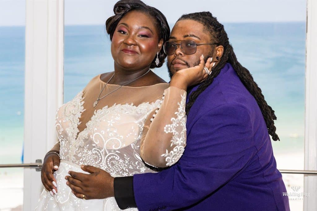 bride is a woman of color, wearing a white gown, man is embracing her around the waist, he is wearing a purple jacket, Orlando, FL
