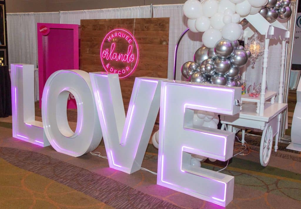 LOVE letters spelled out and lit up with pink highlights as a part of a photo booth area, Central FL