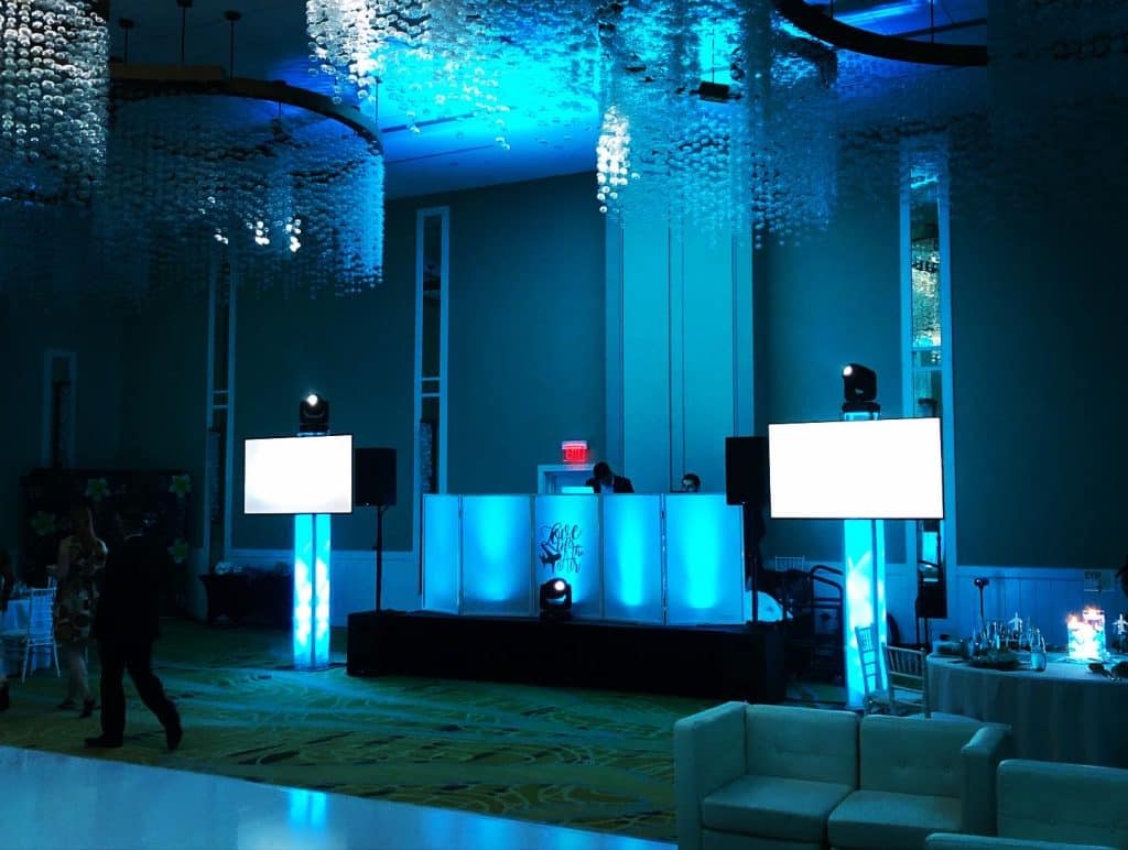 DJ booth set up with soft blue lighting and two tv screens set up on either side of the booth, Dash of Class Platinum, Orlando, FL