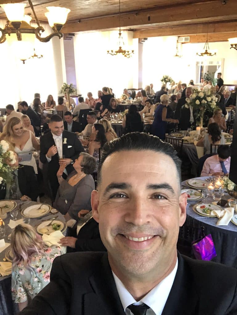 DJ taking a selfie of himself with the background of guests at their tables, Orlando, FL