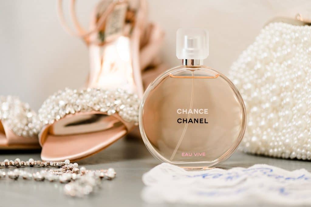 perfume bottle in front of shoes and other jewelry