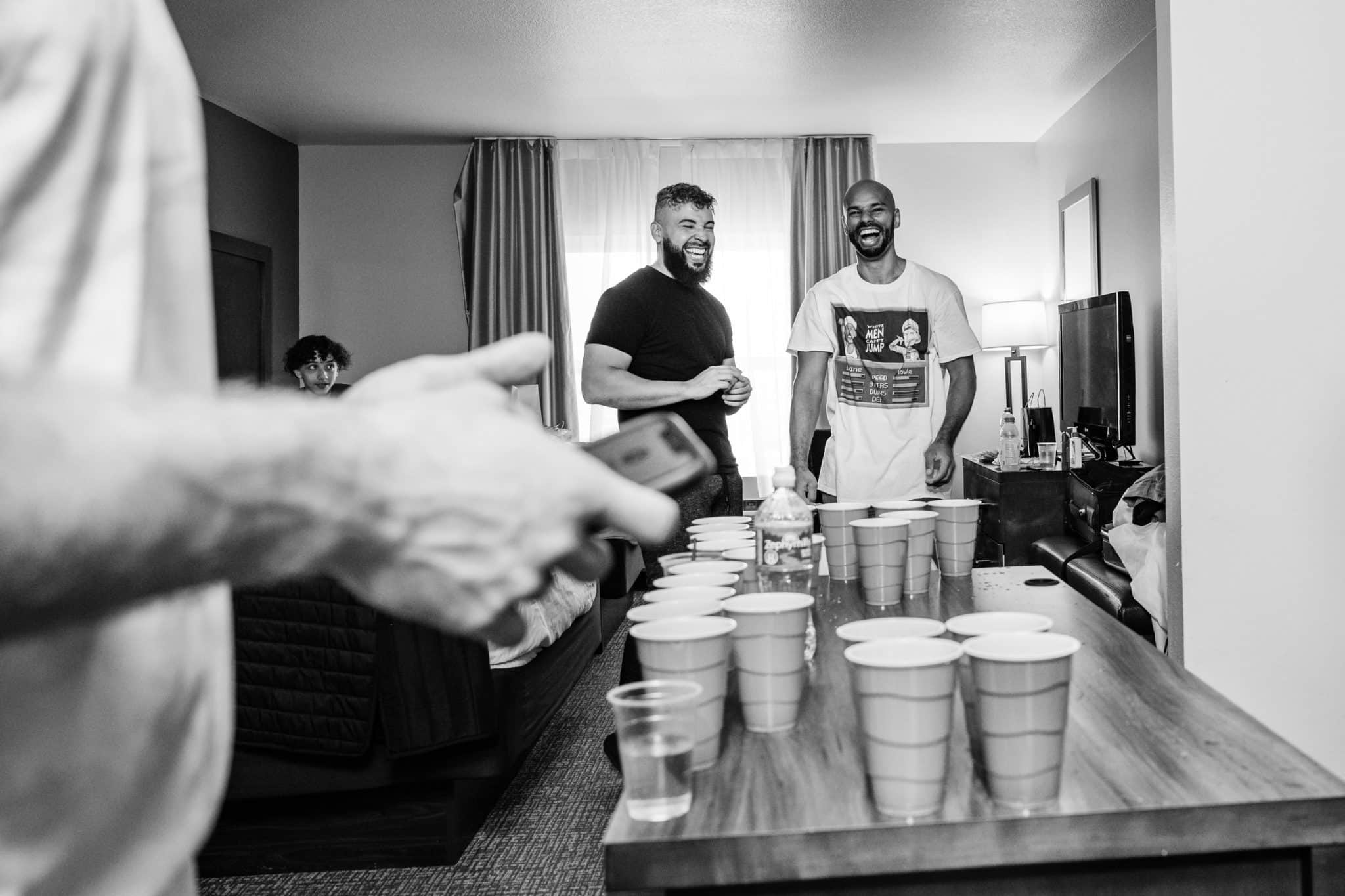 blac and white image of guys playing beer pong at a table