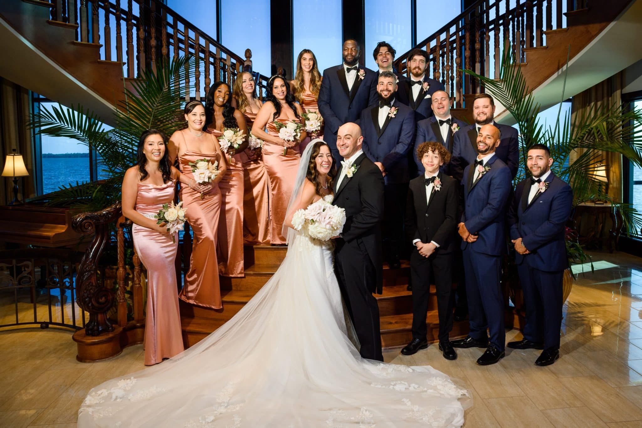 bride and groom pose on staircase with entire wedding party