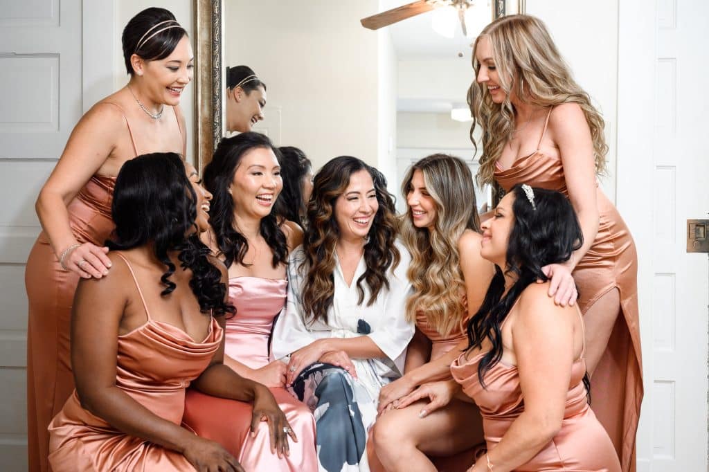 bride smiles in picture with bridesmaids
