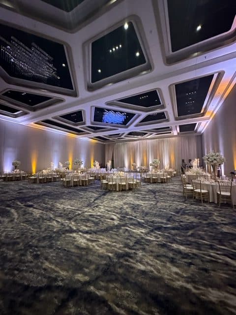 Indoor ballroom venue, uplighting of purple and orange, carpet, round tables, One Night Only, Orlando, FL