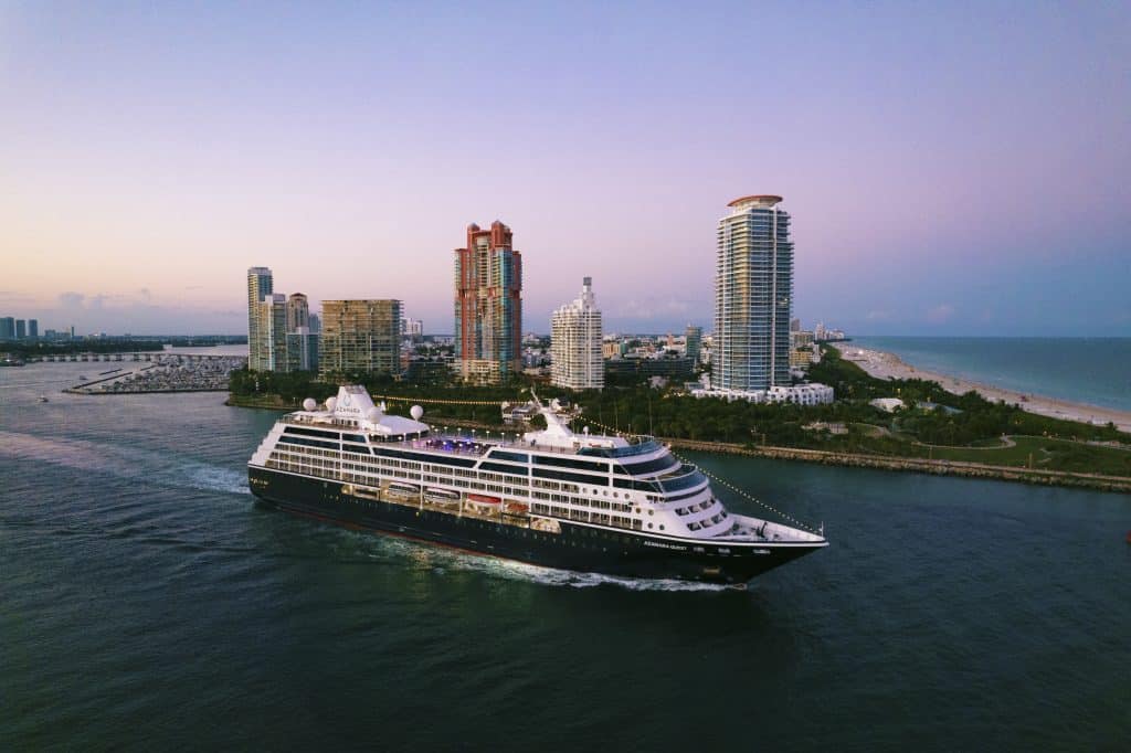 Cruise ship traveling past the city, purple skies, Cruise Island Travel, Orlando, FL