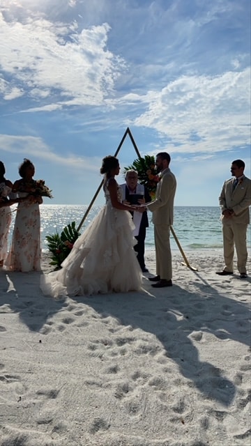 Outdoor ceremony on the beach, wedding party watches on, clear blue skies, Orlando, FL