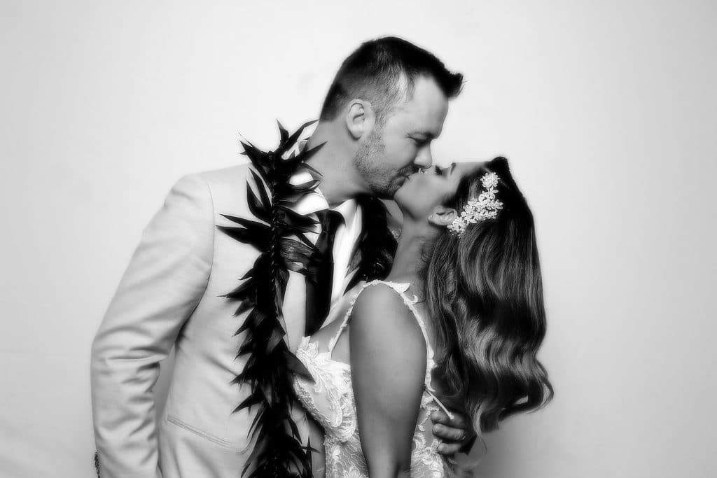 Bride and groom kissing on their wedding day in a black and white photo
