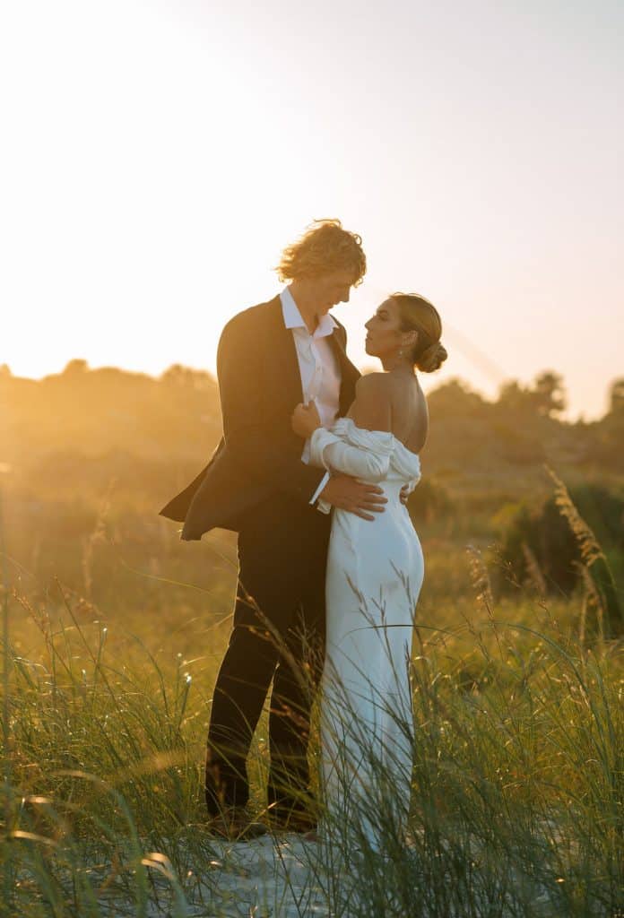 Bride and Groom in a field, facing each other, in an embrace at sunset, Central FL