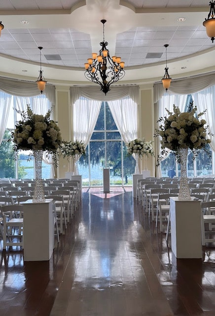 indoor venue, large windows, tall flower vases on either side of the aisles, white curtains, Orlando, FL