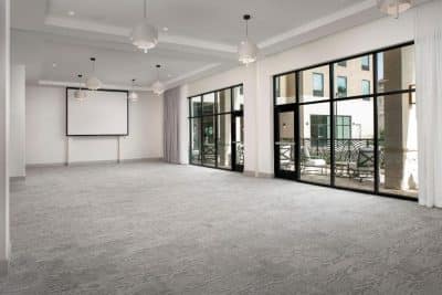 Event space, hotel, large floor length windows, grey carpet, white walls, screen, Central, FL