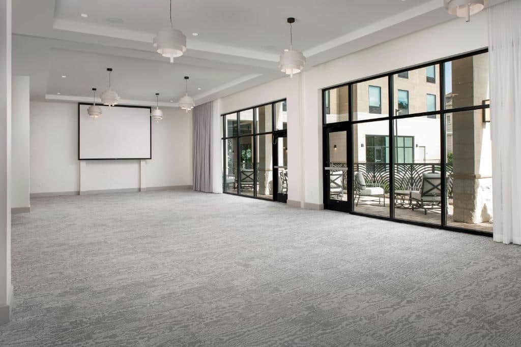 Event space, hotel, large floor length windows, grey carpet, white walls, screen, Central, FL