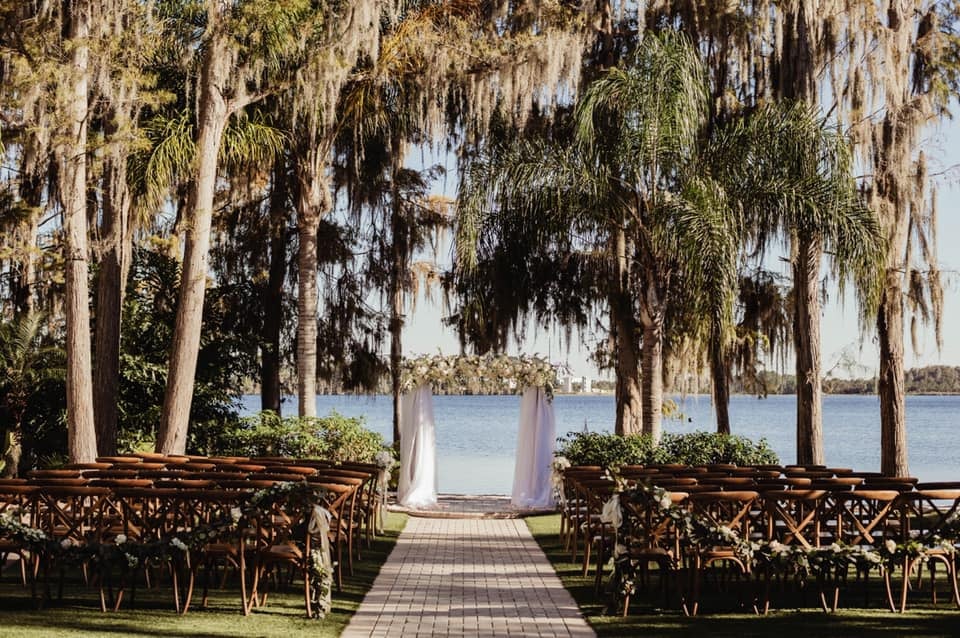 wedding ceremony set up, outdoors, palm trees with an altar at the front, white brick walkway, on the water, Central FL.