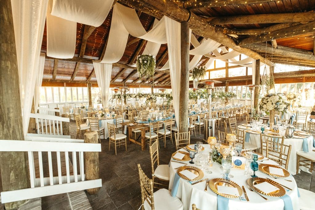 wedding reception set up with white tablecloths, light blue napkins, gold chargers, gold chairs with white cushions, Paradise Cove, Central FL