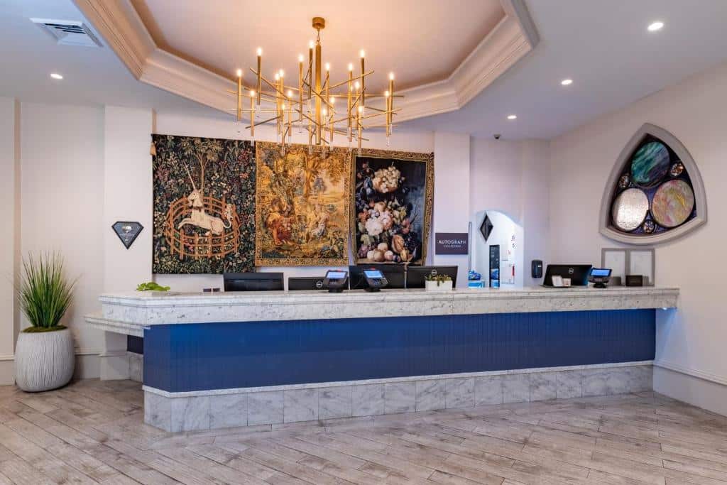 Front desk reception, entry to the hotel, blue, gold and silver decor, large chandelier hanging over the desk, Central FL