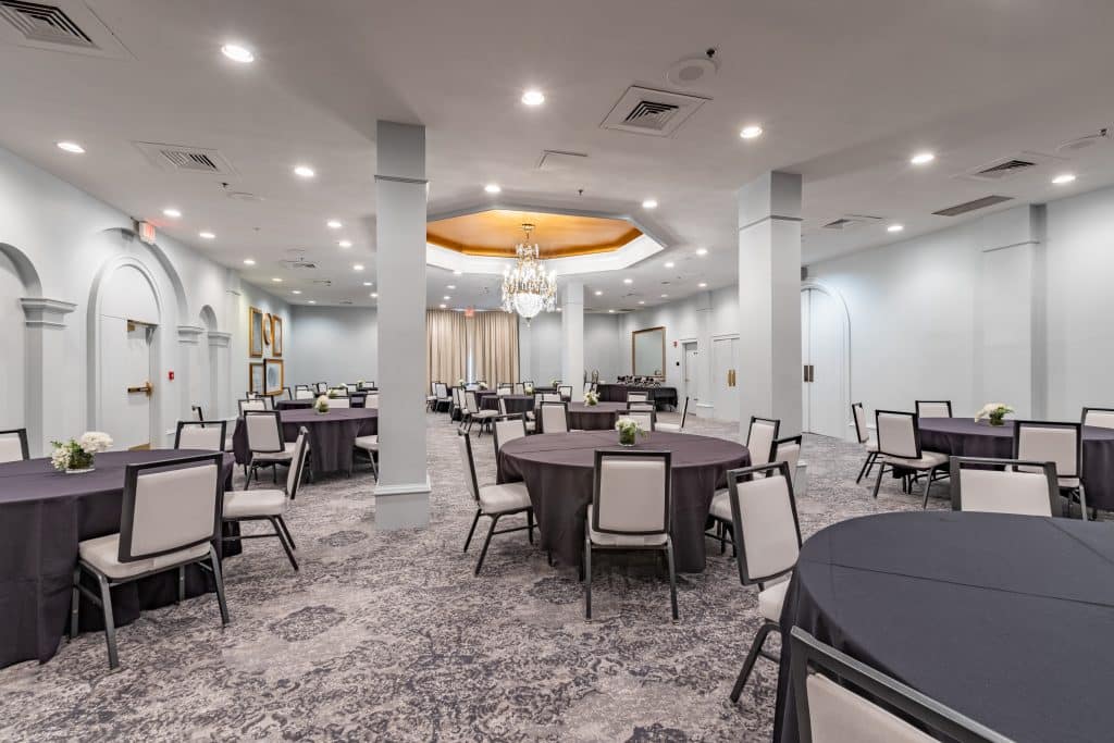 conference room set up with large round tables, white and black chairs, white columns throughout the room, Castle Hotel, Central FL