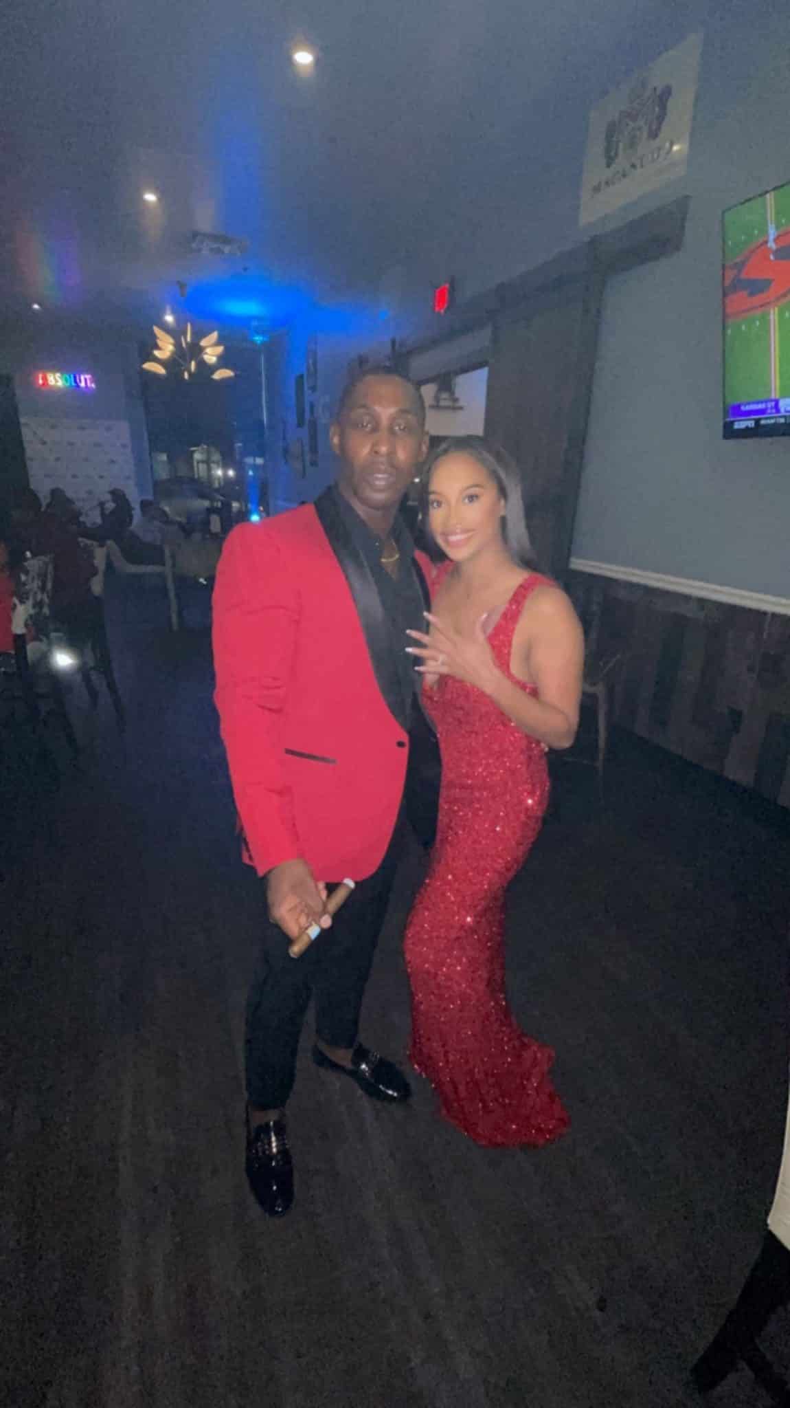 man and woman wearing matching red formal attire pose together for picture